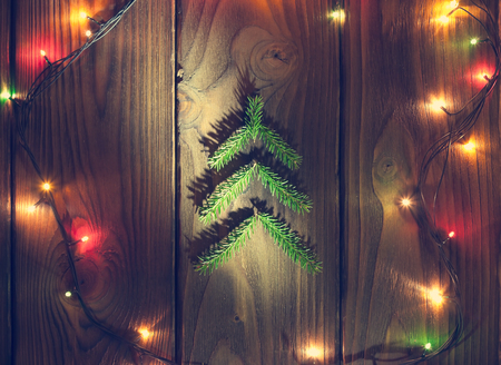 little fir tree branch in the shape of xmas tree on a wooden desk as symbol of the Happy New Year and Merry Christmasの写真素材