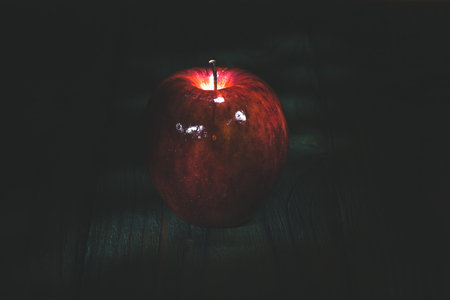 food concept - apple on a wooden board in the darknessの写真素材
