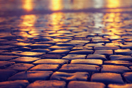 cobblestone pavement on a square with defocused background in the eveningの写真素材