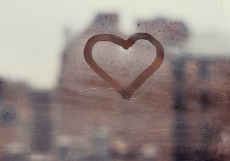 love concept, heart silhouette on a window glass in an old european townの写真素材