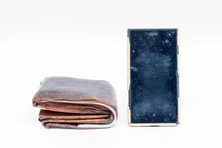 Old wallet brown leather and dirty smart phone on white background