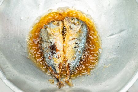 Two face-to-face fish, frying in a frying pan, boiling oilの写真素材