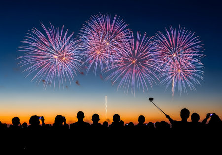 Vibrant fireworks lighting up the night sky with people watching and celebrating together perfect for New Year and festive designsの素材