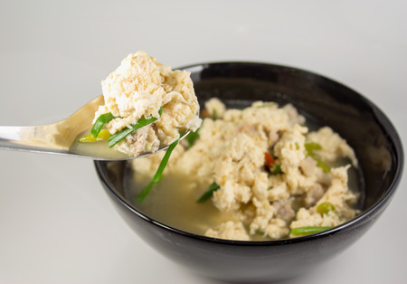 Fried Eggs in Clear Soup in black bowl on white backgroundの写真素材