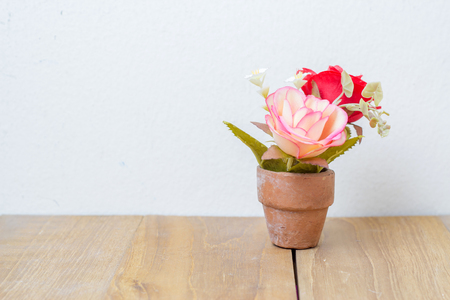 plastic flower in pot on wooden boardの写真素材