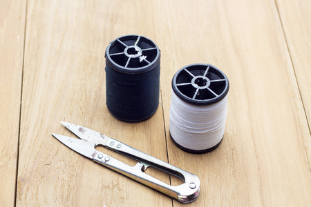 scissor and thread on wooden boardの写真素材