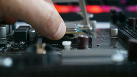 Close-up of a man's hand is repairing the motherboard.の写真素材