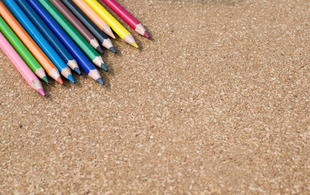 Colour pencils on cork board background close up