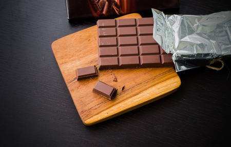 Pack of Dark chocolate bar on the cutting boardの写真素材