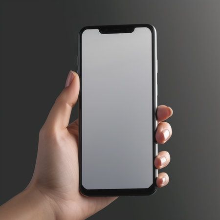 Female hand holding black smartphone with blank screen on gray background. Mock upの素材