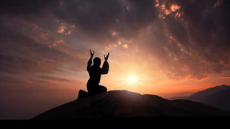 Silhouette of a woman meditating on top of a mountain at sunset, praying for GOD conceptの素材