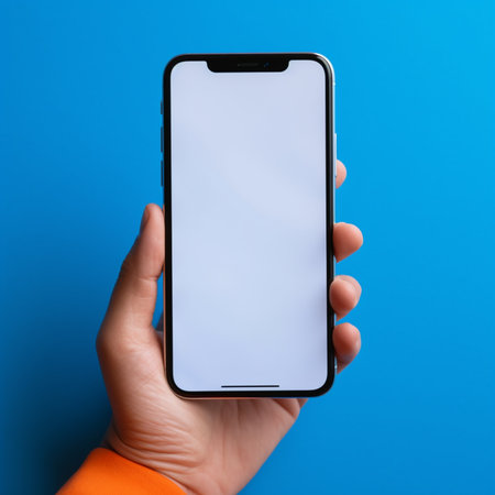 male hand holds a smartphone with a blank screen on a blue backgroundの素材