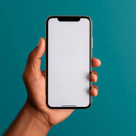male hand holds a smartphone with a white screen on a blue backgroundの素材