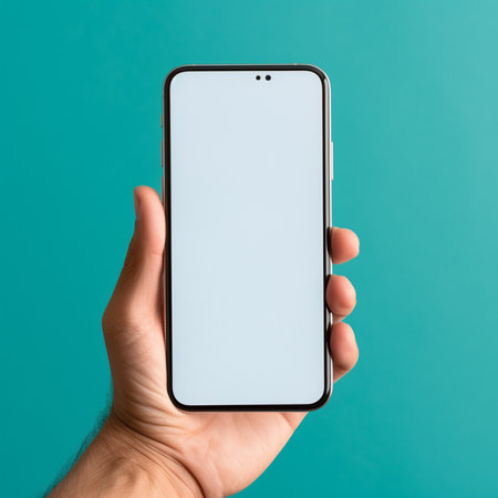 male hand holds a smartphone with a white screen on a turquoise backgroundの素材