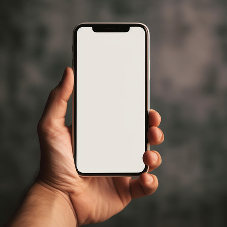 male hand holding a phone with a white screen on a dark backgroundの素材