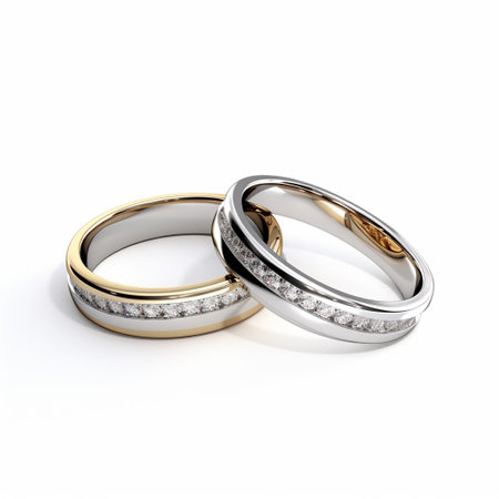 3D illustration two gold and silver wedding rings with diamonds on a white backgroundの素材