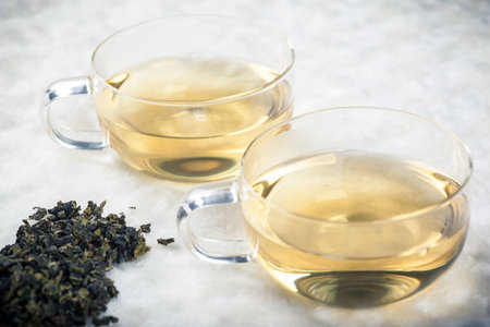 Tea leaves beside two tea cups
