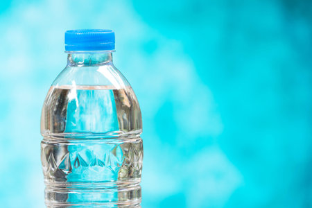 close up plastic water bottles with caps on blue backgroundの写真素材