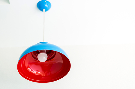 Blue and Red Metal Lamp Hanging on a Wallの写真素材