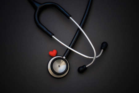 Stethoscope and red heart on black background. Cardiology concept. World health day and healthcare concept.の写真素材