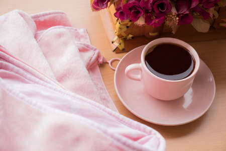 pink cup of black coffee and the pink floral, over wood texture background. Flat lay concept. top view. morning coffee. International Coffee Day.の写真素材