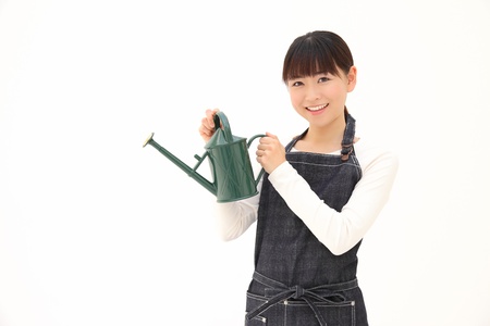 Young Asian woman with a Watering Can on a white backgroundの写真素材