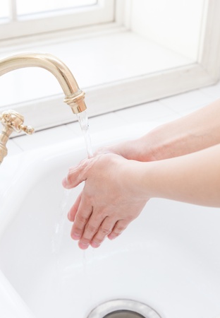 Hand-washing sink in the hands of a woman by the windowの写真素材