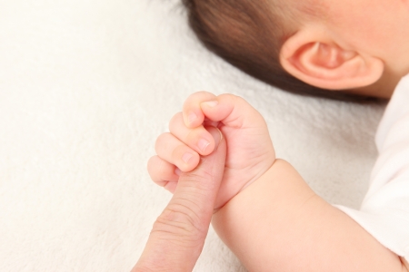 Asian parents and children hold hands in white backgroundの写真素材
