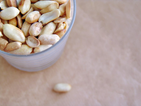 peanut peeled roasted nuts in a transparent glass top view blotchy blurry