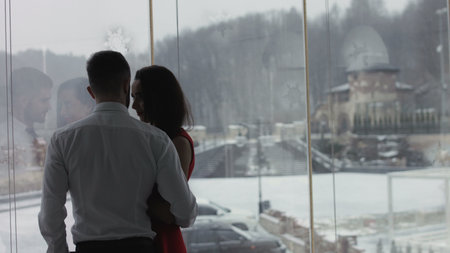 Young couple is standing near the window