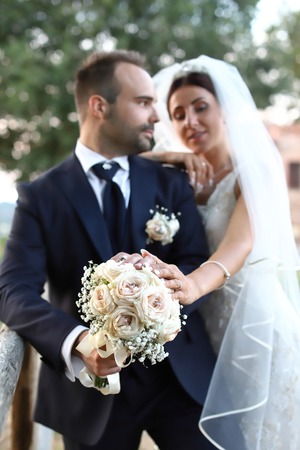 Happy bride and groom in wedding day. Wedding couple in love, newlyweds. Wedding concept. wedding bouquet in the foregroundの写真素材