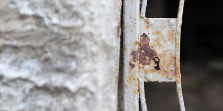 Closeup of old rusty metal lock and keyhole on a old iron door as a beautiful vintage background. Fragment of old rusty gateの写真素材