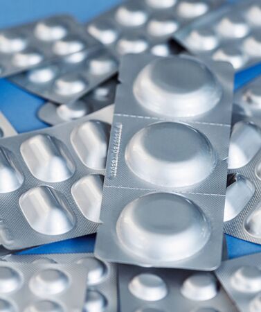 Different blister of pills. Medical and Global healthcare concept. Pharmaceutical industry. Light blue paper background with copy space.の写真素材