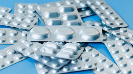 Different blister of pills. Medical healthcare concept. Light blue paper background with copy space.の写真素材