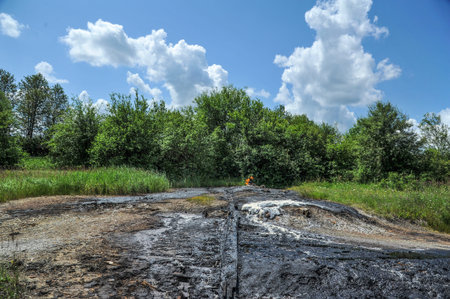 Industrial oil pollution on the surface of the soil near the old oil wells is an environmental...