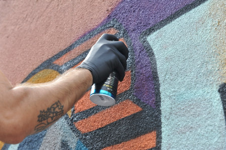 Street artist draws colorful graffiti on the concrete wall. Concept of colorful modern art.の写真素材