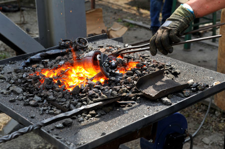 Red hot metal in a forging furnace preparing for forging process at workshop.