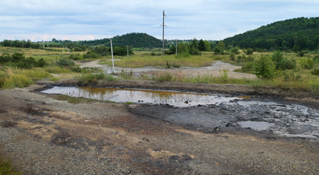 Industrial oil pollution on the surface of the soil near the old oil wells is an environmental...