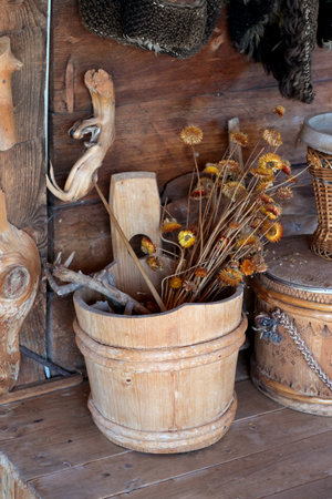 Old wooden bucket with dried flowers for interior decorationの写真素材