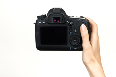 DSLR camera in hand  over gray backgroundの写真素材