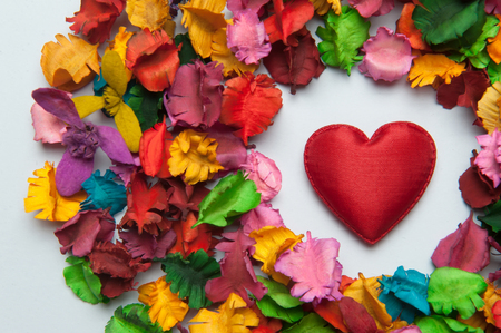 Heart in the center of a colorful backdrop flower leavesの写真素材