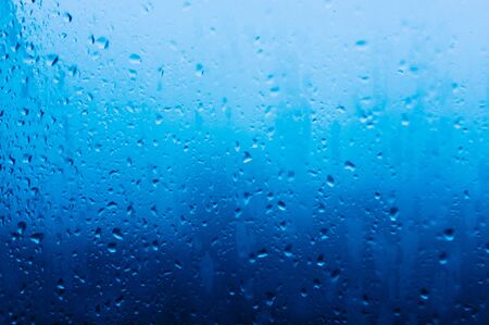 Drops water on window. Spotted abstract texture background. Spring wet weather. Droplets on glass. Fit to autumn.の写真素材