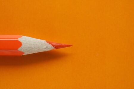Macro photo of orange pencil on orange paperの写真素材