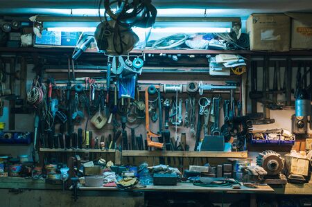 Workshop scene. Old tools hanging on wall in workshop. Vintage retro garage style. Old wrenches hanging wall in old garage. Garage tools.の写真素材