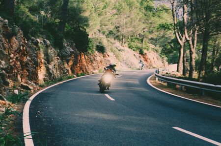 Motorcyclist on mountainous road, enjoying tour along Mallorca, summertime activities, wonderful mountain landscape, extreme vacation conceptの写真素材