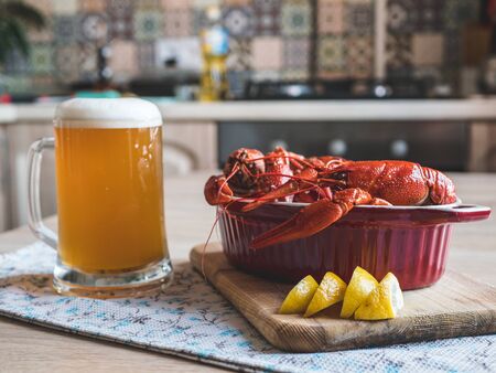 Red crayfish with lemon. In the background, beer is poured into a glass.の写真素材