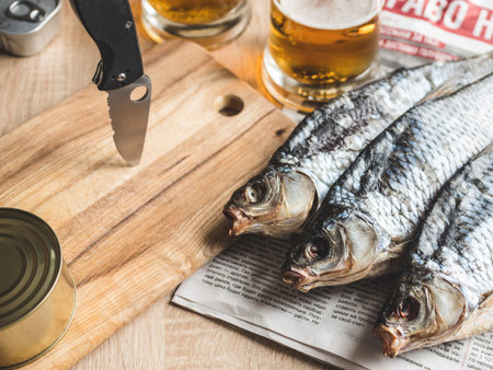 Light beer and smoked dry fish on the table.