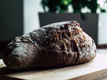 Fresh baked rye bread and sliced bread on rustic wooden board. Closeup.