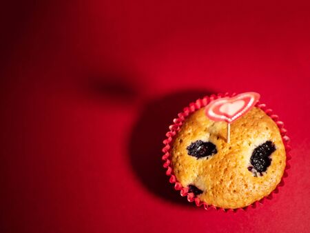 Muffins with blueberries and raspberries. Cupcakes with Valentine's Day decor. Flat lay. Banner.の写真素材