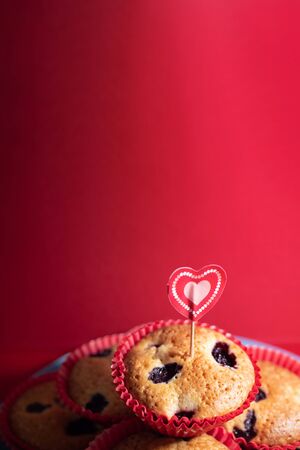 Muffins with blueberries and raspberries. Cupcakes with Valentine's Day decor. Flat lay. Banner.